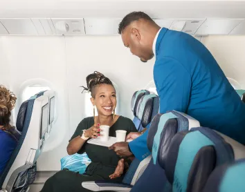 Service Aircalin Steward qui apporte du jus à une cliente