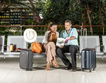 Couple à l'aéroport Couple assis sur un banc d'aéroport